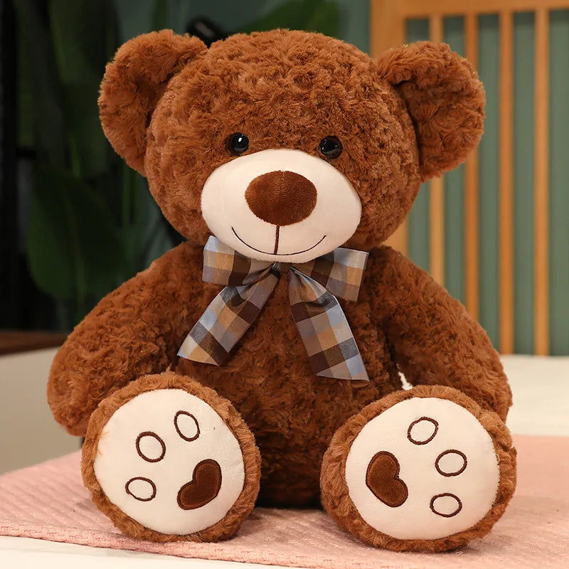 Osito de peluche da marca Minimalist House Shop, fofo e macio, com detalhes de pelúcia bege e olhos escuros.